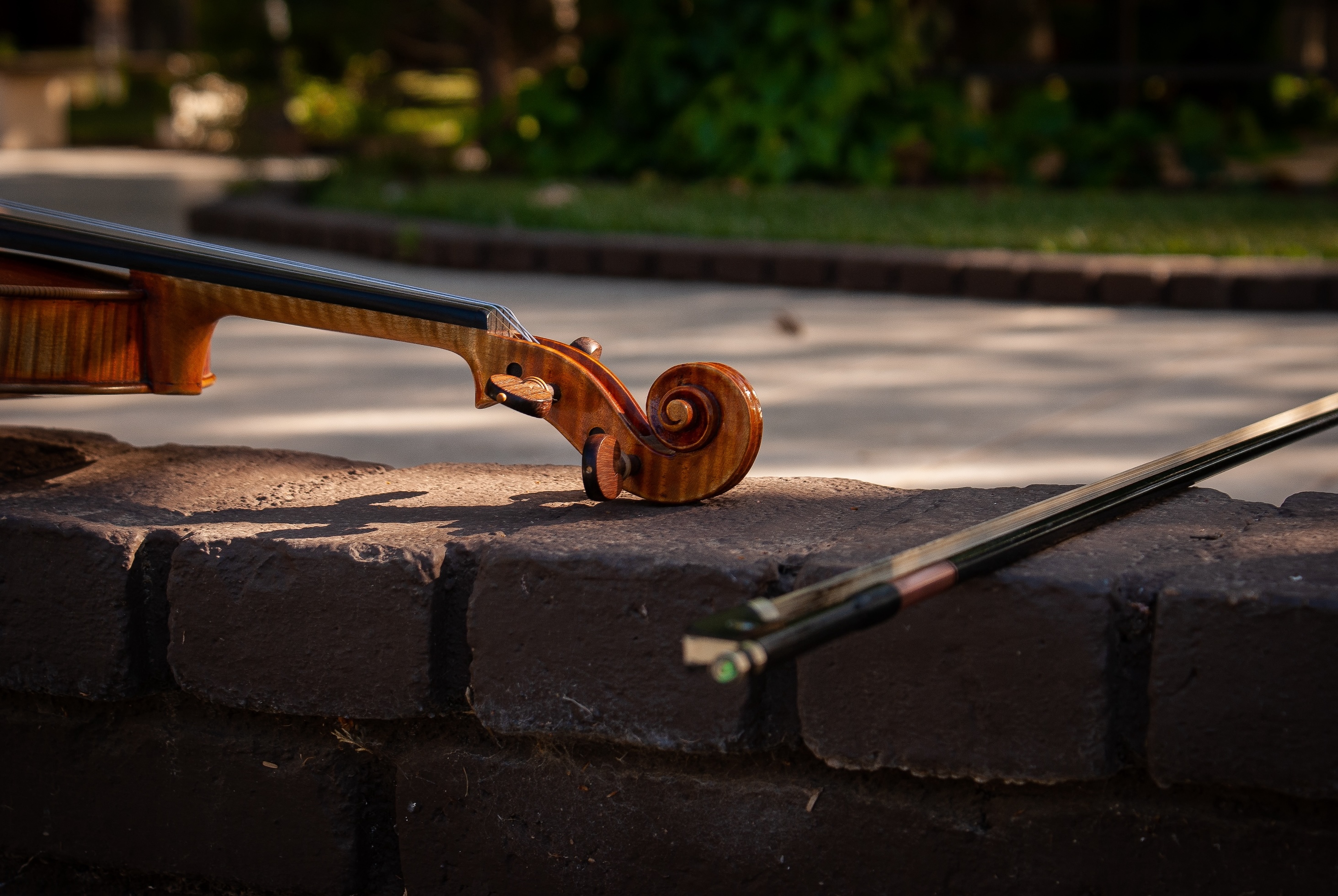 Violín de Yael Magaña apoyado en un muro de piedra al atardecer